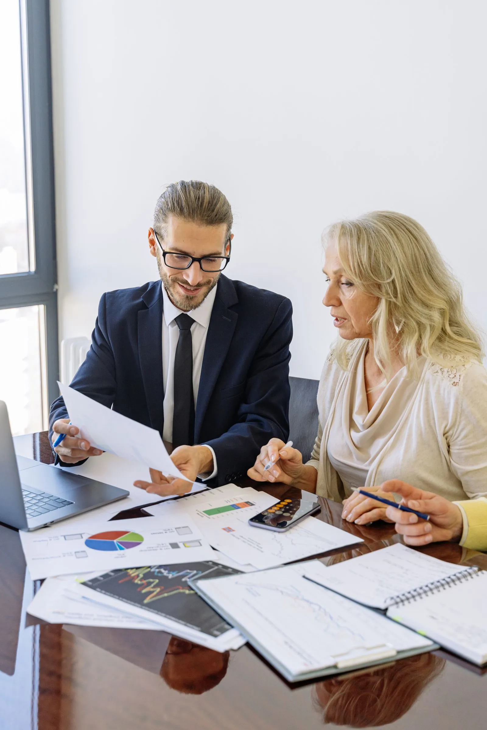 Advisor and client reviewing a services roadmap at a light meeting table